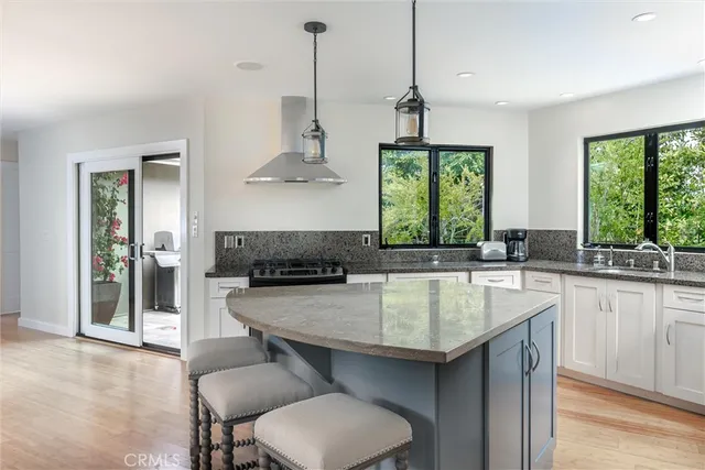 a kitchen with a stove a sink and a wooden floors