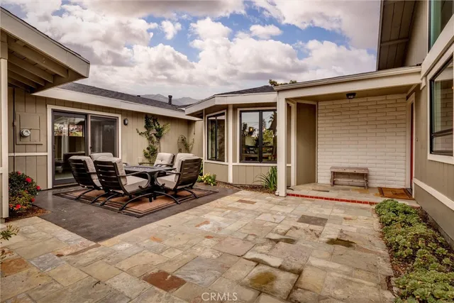 a view of a patio with table and chairs and floor to ceiling window