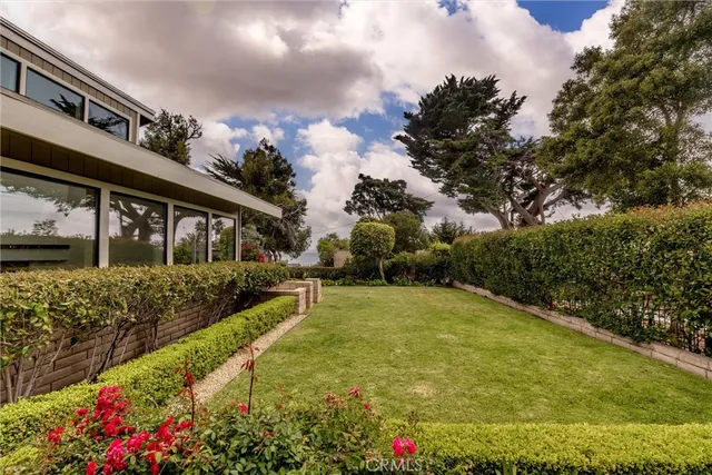 a view of a house with a big yard and potted plants
