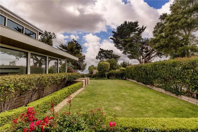 a view of a house with a big yard and potted plants