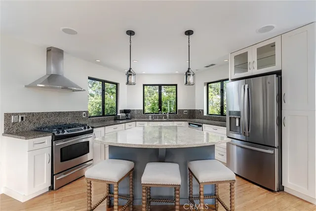 a large kitchen with granite countertop a stove a sink and a refrigerator