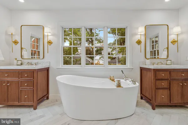 a bathroom with a bathtub a mirror a sink and a toilet