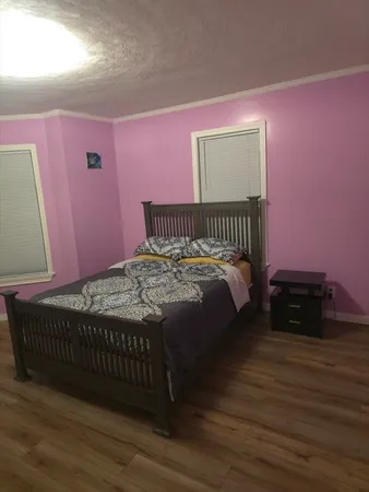 a bedroom with a bed and a flat tv screen on dresser