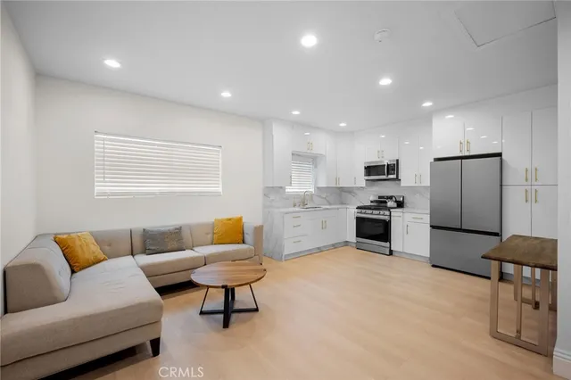 a living room with furniture and kitchen view