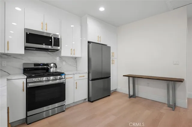 a kitchen with stainless steel appliances granite countertop a stove a refrigerator and a microwave