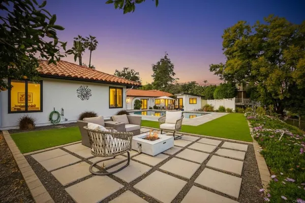 a view of a patio with couches table and chairs and potted plants