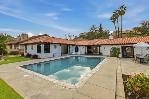 a front view of a house with swimming pool having outdoor seating