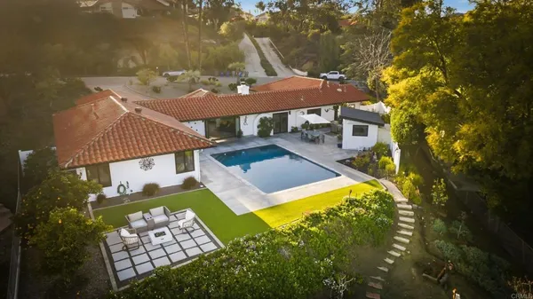 an aerial view of a house with swimming pool patio and outdoor seating