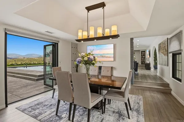 a dining room with furniture a chandelier and wooden floor