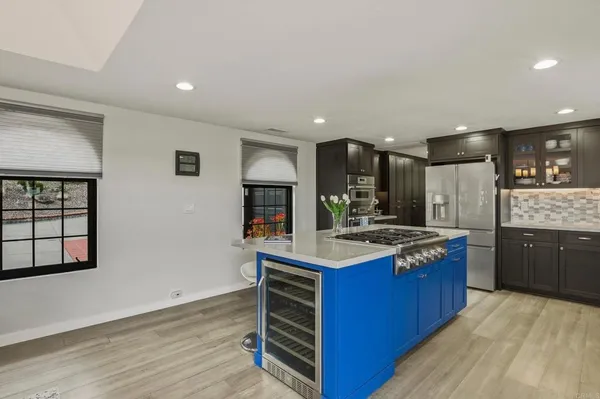 a kitchen with stainless steel appliances granite countertop a stove cabinets and wooden floor