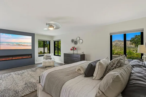 a bedroom with a large bed and a flat tv screen on dresser
