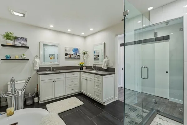 a bathroom with a double vanity sink mirror and shower