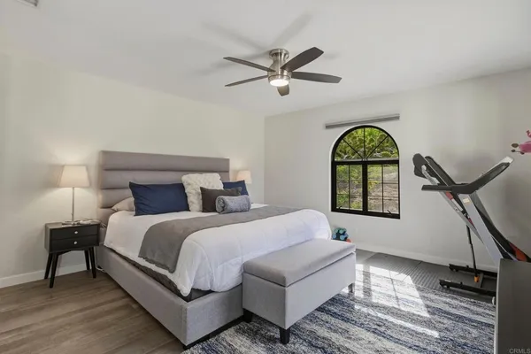 a bedroom with a bed a chandelier and a window