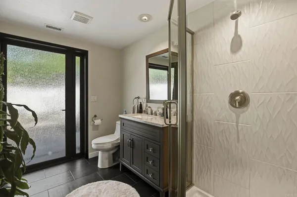 a bathroom with a granite countertop sink toilet and shower