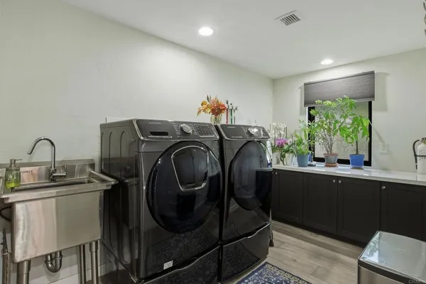 a utility room with sink dryer and washer