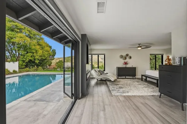 a living room with yard floor to ceiling window and kitchen view