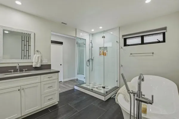 a spacious bathroom with a double vanity sink a mirror and a shower