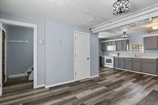 a open kitchen with a sink dishwasher a stove and a refrigerator with wooden floor