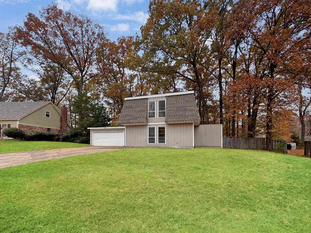 a view of a house with a yard and tree
