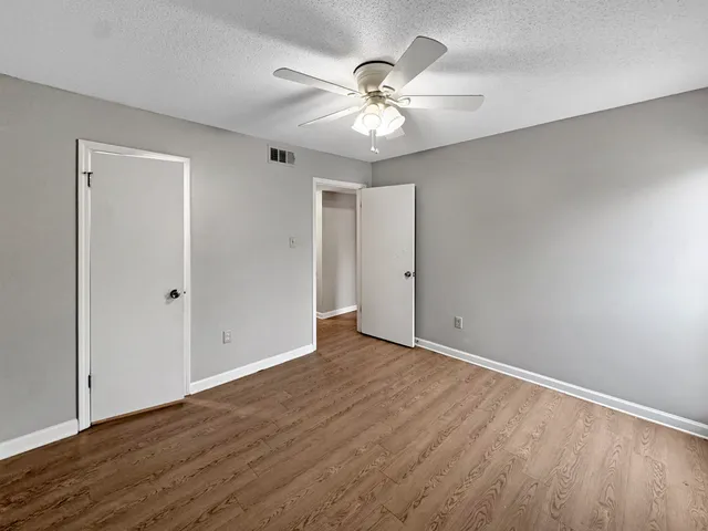 a view of an empty room with wooden floor