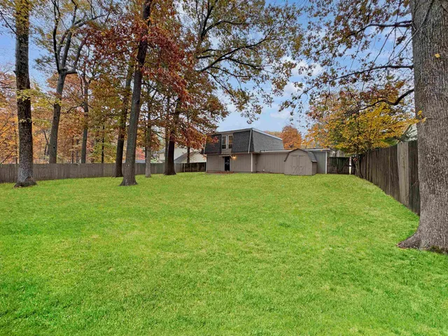 a view of a yard with a house in the background