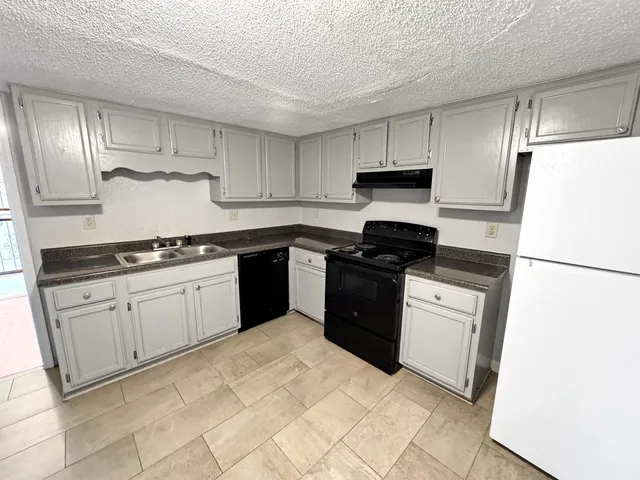 a kitchen with stainless steel appliances granite countertop a refrigerator sink and cabinets