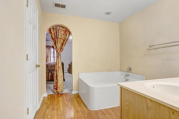 a bathroom with a tub sink and a mirror