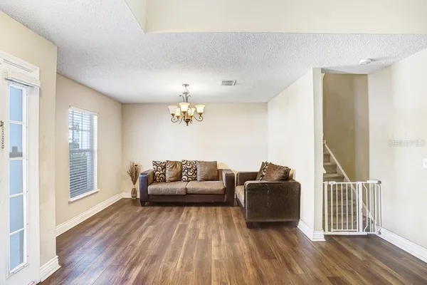 a living room with furniture and wooden floor