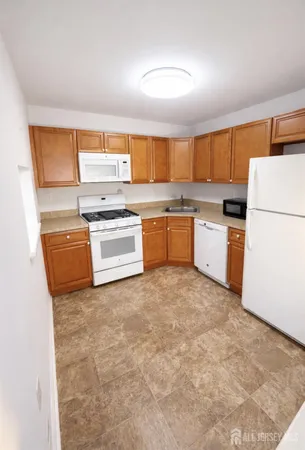 a kitchen with a sink a stove top oven and white kitchen