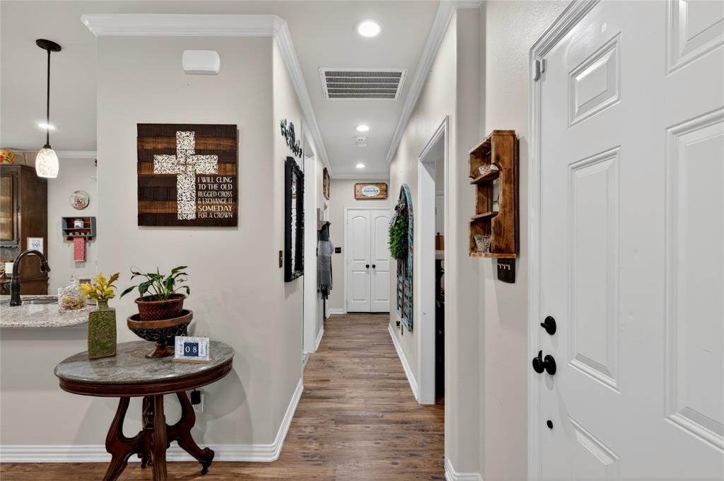 701 West Lamberth Road Sherman, TX 75092 - Photo 20 of 37 Hallway featuring wood-finish flooring, white paneled doors, recessed lighting, and crown molding