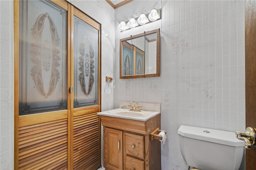 62 Stoney Road Tamaqua, PA 18252 - Photo 32 of 61 A well-lit bathroom with patterned glass doors and classic wood vanity.