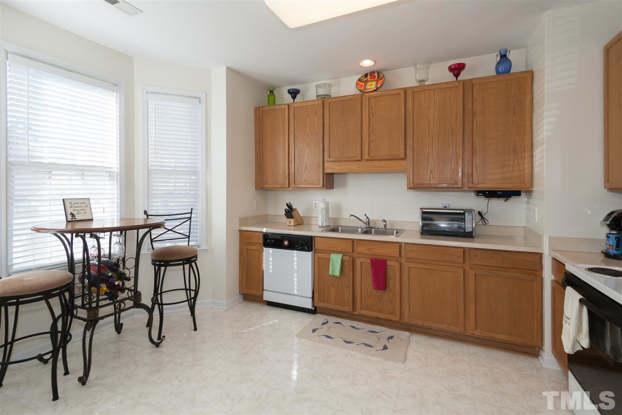 5602 Slide Rock Lane Raleigh, NC 27613 - Photo 2 of 19 a kitchen with granite countertop a table chairs stove and cabinets