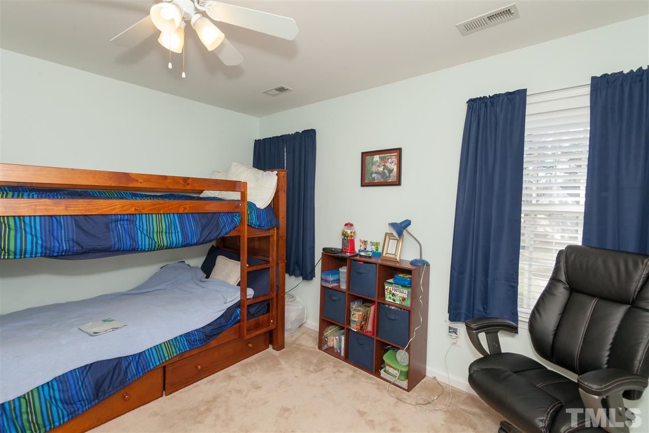 5602 Slide Rock Lane Raleigh, NC 27613 - Photo 15 of 19 a bedroom with a bed and a chair