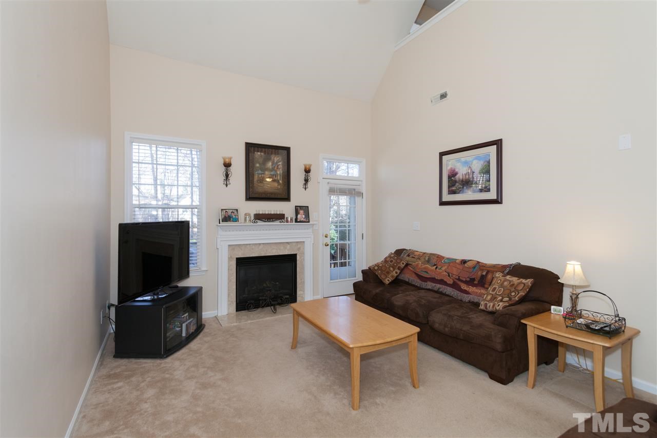 5602 Slide Rock Lane Raleigh, NC 27613 - Photo 5 of 19 a living room with furniture a fireplace and a flat screen tv