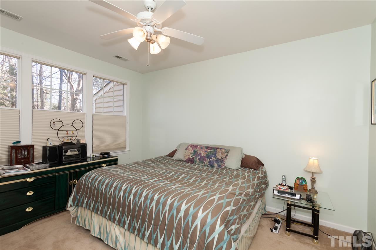 5602 Slide Rock Lane Raleigh, NC 27613 - Photo 6 of 19 a bedroom with a bed and a chandelier