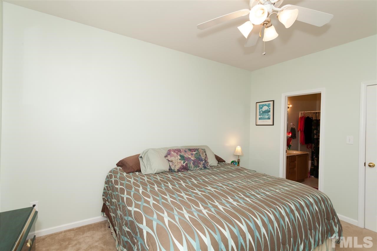 5602 Slide Rock Lane Raleigh, NC 27613 - Photo 7 of 19 a bedroom with a bed and a chandelier