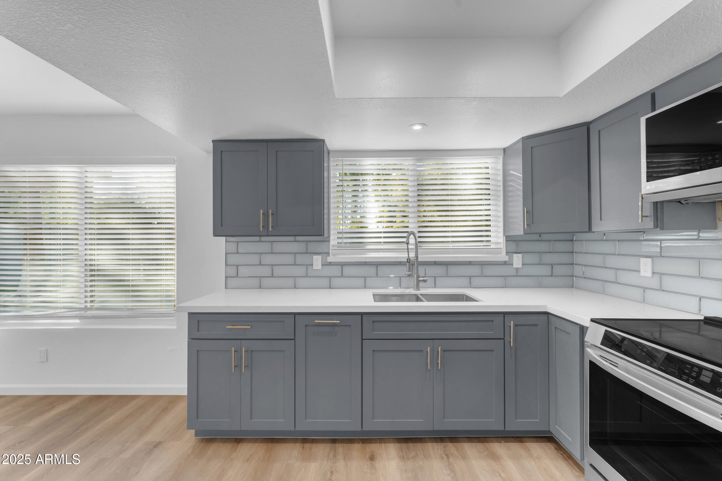 108 South Morning Ridge Drive Gilbert, AZ 85296 - Photo 11 of 49 a kitchen with stainless steel appliances granite countertop a sink a stove a microwave and wooden cabinets