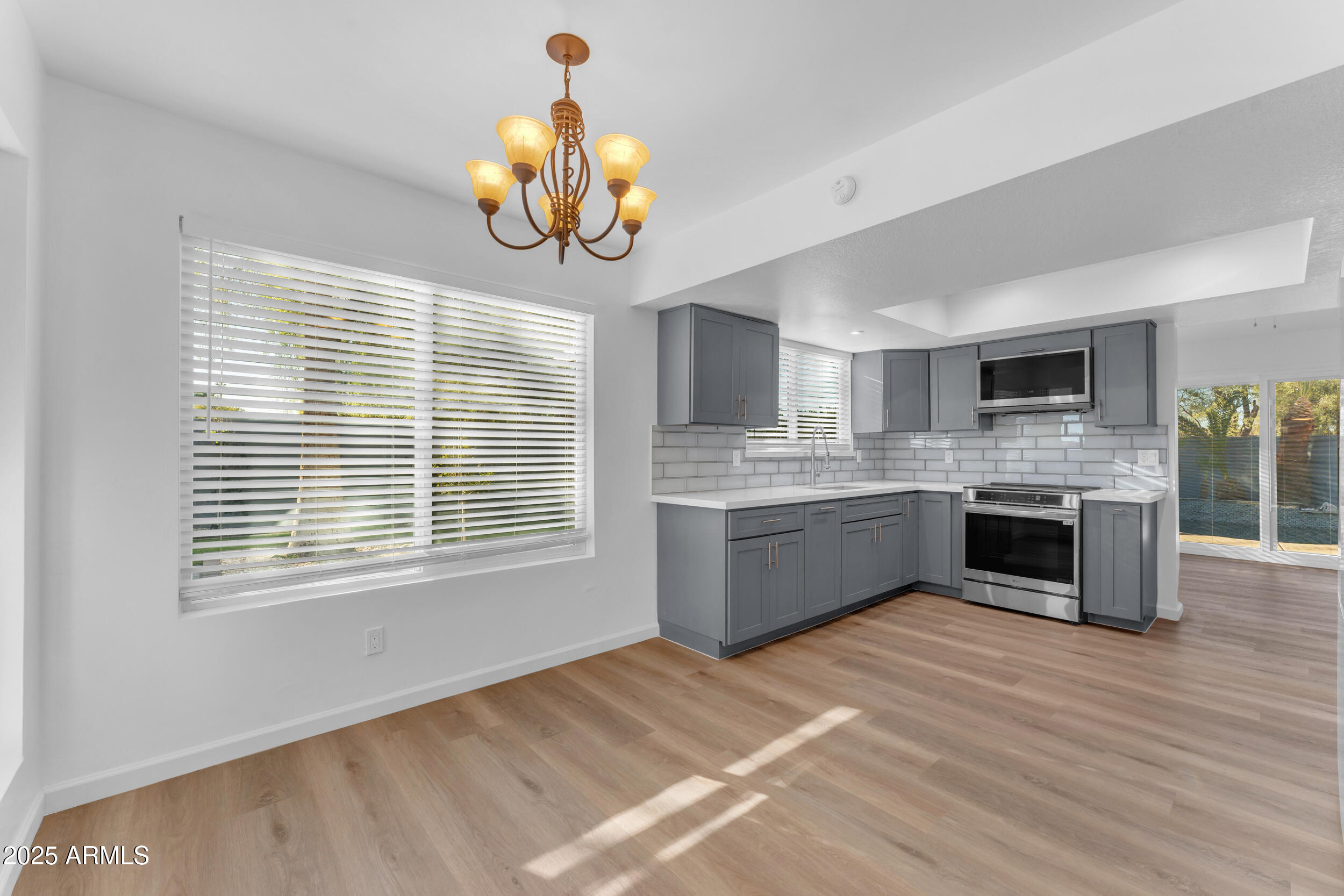 108 South Morning Ridge Drive Gilbert, AZ 85296 - Photo 12 of 49 a kitchen with a stove a sink cabinets and a wooden floor