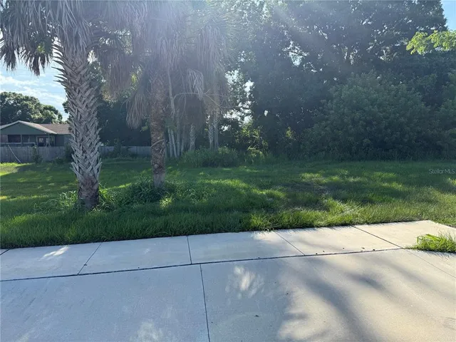 a view of a street with a house in background