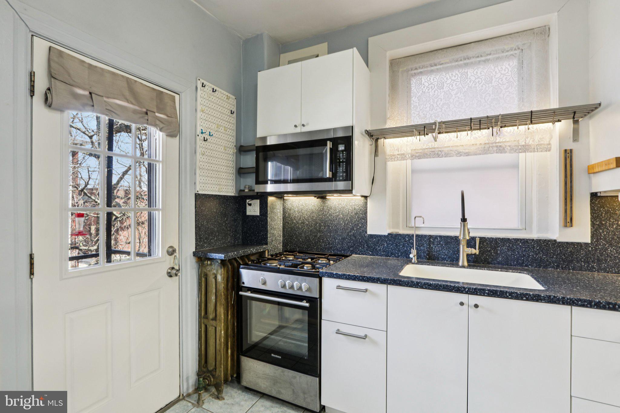 1003 South 46th Street, Unit 4 Philadelphia, PA 19143 - Photo 17 of 32 a kitchen with stainless steel appliances a stove microwave and sink