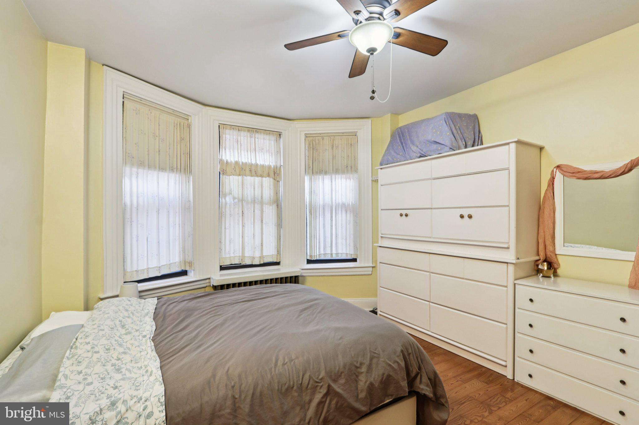 1003 South 46th Street, Unit 4 Philadelphia, PA 19143 - Photo 22 of 32 a bedroom with a bed and a chandelier