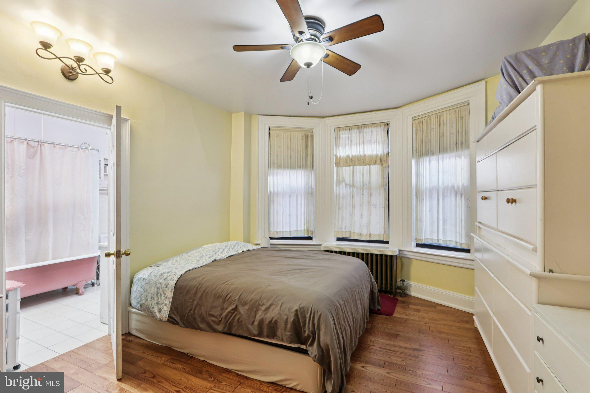 1003 South 46th Street, Unit 4 Philadelphia, PA 19143 - Photo 23 of 32 a spacious bedroom with a large bed and a chandelier