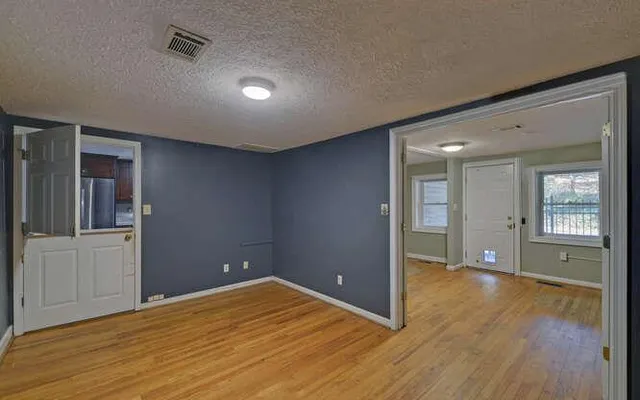 a view of empty room with wooden floor