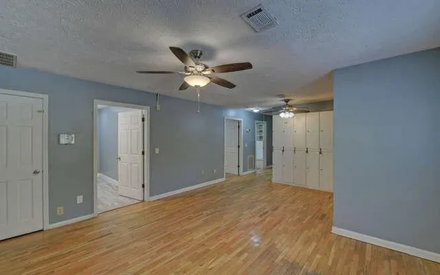 a view of empty room with wooden floor