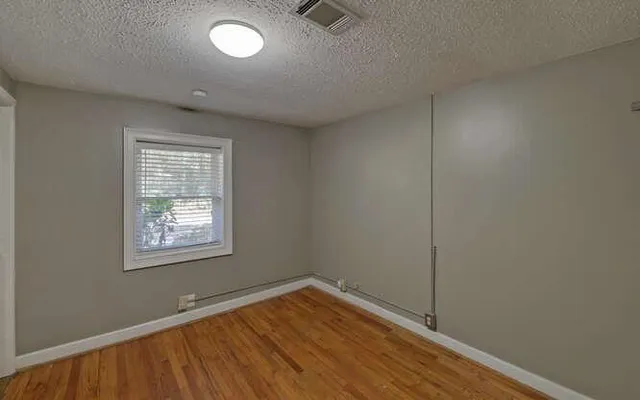 a view of an empty room with cabinet and a window
