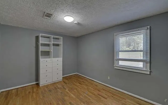 an empty room with closet and wooden door