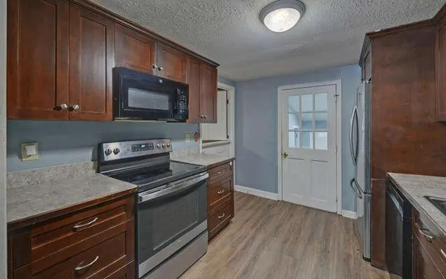 a kitchen with a sink a refrigerator and cabinets