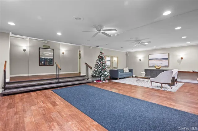 a kitchen with stainless steel appliances granite countertop a stove top oven a refrigerator a dining table and chairs with wooden floor