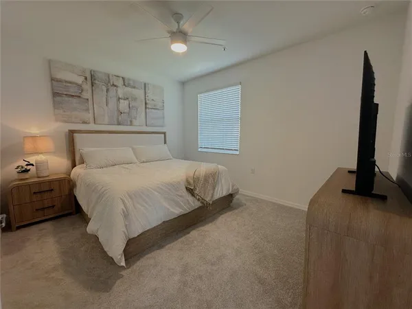 a bedroom with a bed and a painting on the wall