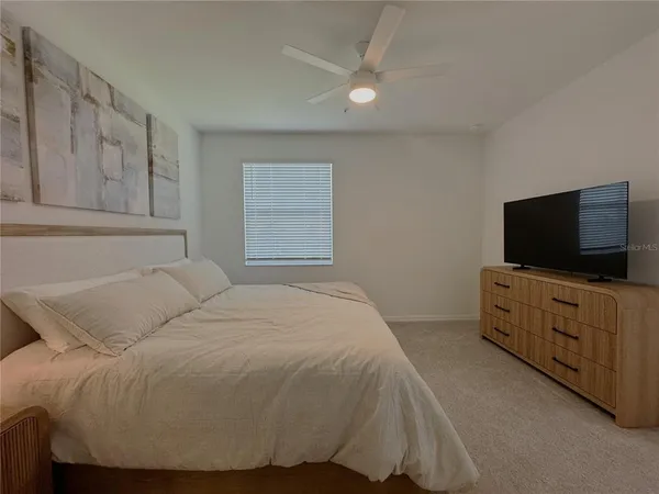 a bedroom with a bed and flat screen tv